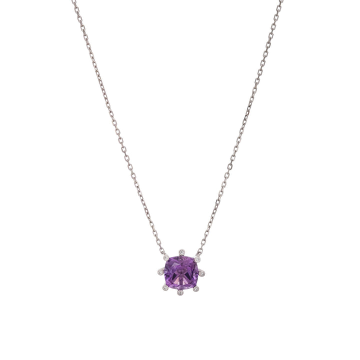 A silver-toned necklace featuring a cushion-cut purple gemstone pendant in a prong setting, flanked by small clear accent stones, shown against a plain white background. 